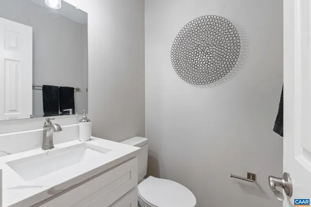 a bathroom with a toilet sink vanity and mirror
