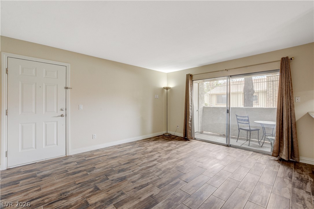 7200 West Pirates Cove Road, Unit 1026 Las Vegas, NV 89145 - Photo 5 of 35 This bright living space features wood-look tile flooring and a private balcony.