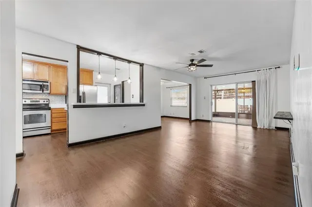 a view of a livingroom with wooden floor and a ceiling fan