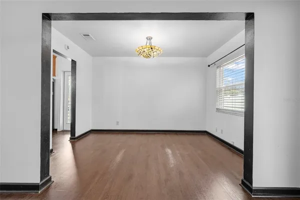 an empty room with wooden floor and a large window