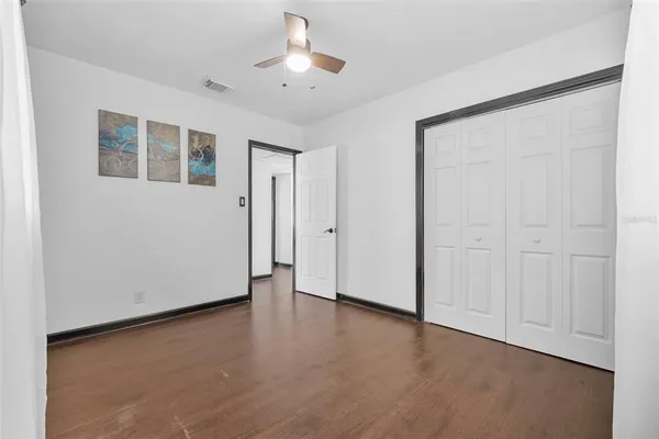 an empty room with wooden floor and window