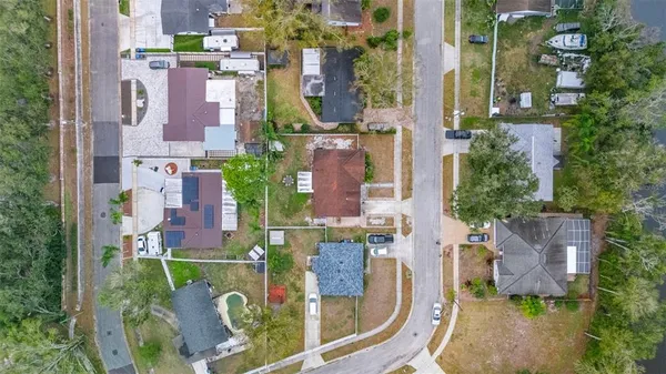 an aerial view of residential houses with outdoor space and lake view