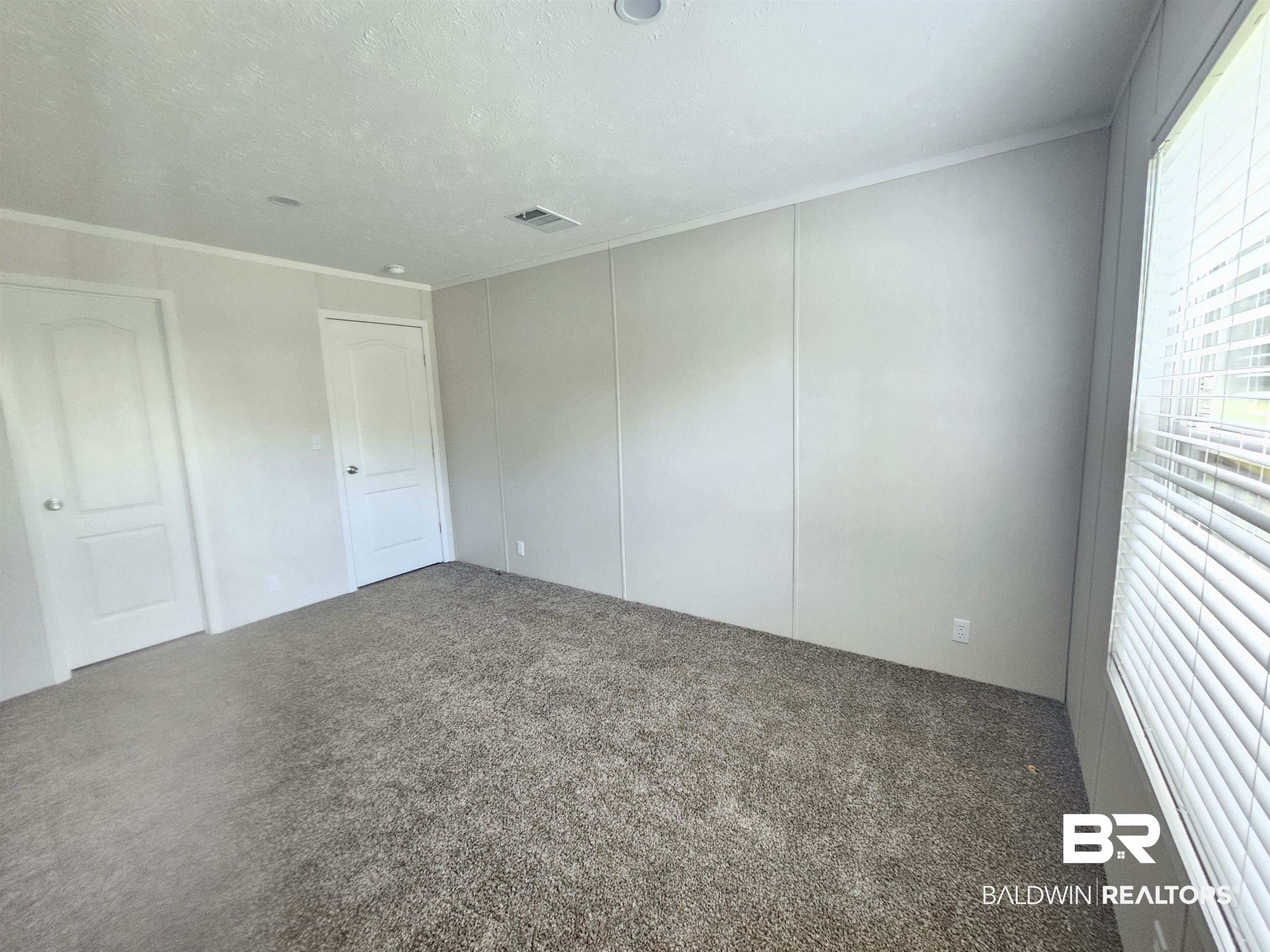 1863 Wait Road Monroeville, AL 36460 - Photo 18 of 38 Carpeted spare room with crown molding and a textured ceiling