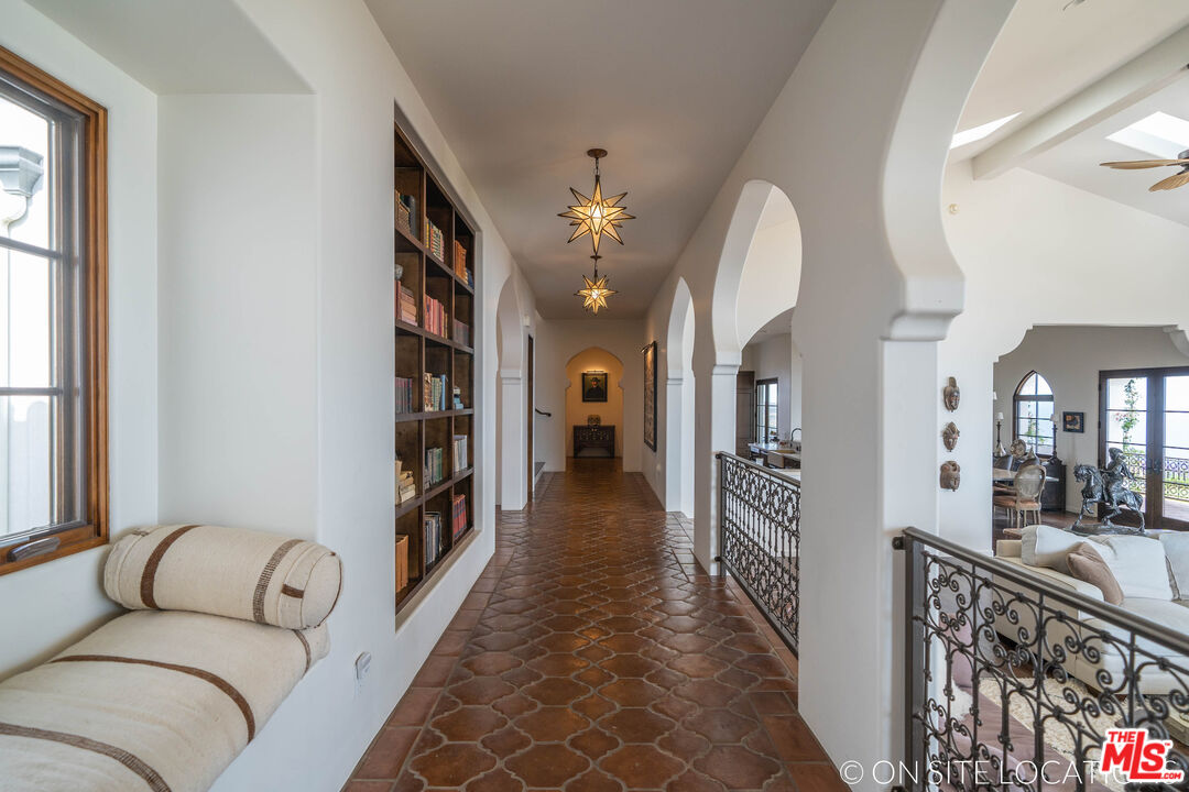 9785 Deer Creek Road Malibu, CA 90265 - Photo 14 of 75 a hallway with furniture and a chandelier