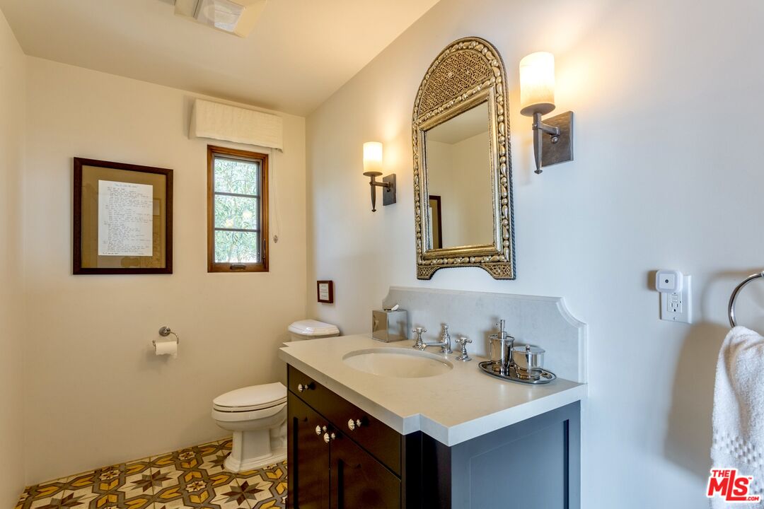 9785 Deer Creek Road Malibu, CA 90265 - Photo 19 of 75 a bathroom with a sink a toilet and mirror