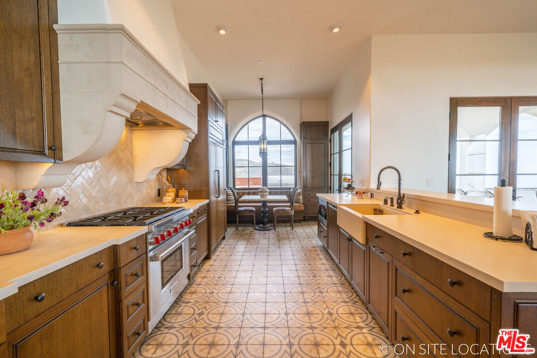 9785 Deer Creek Road Malibu, CA 90265 - Photo 20 of 75 a kitchen with stainless steel appliances a sink stove and cabinets