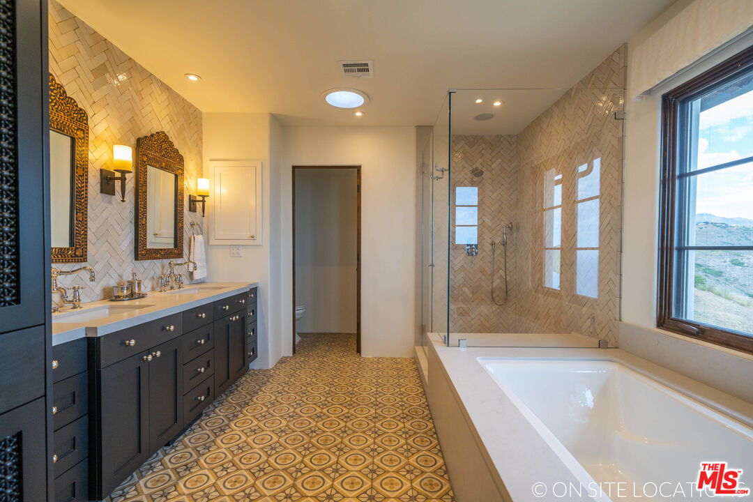 9785 Deer Creek Road Malibu, CA 90265 - Photo 29 of 75 a bathroom with a tub sink shower and a mirror
