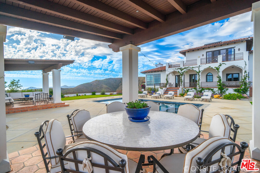 9785 Deer Creek Road Malibu, CA 90265 - Photo 49 of 75 a dining room with furniture a garden and patio