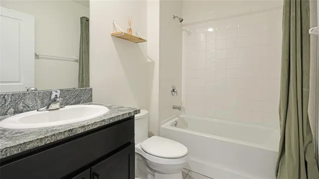 a bathroom with a granite countertop shower sink and mirror