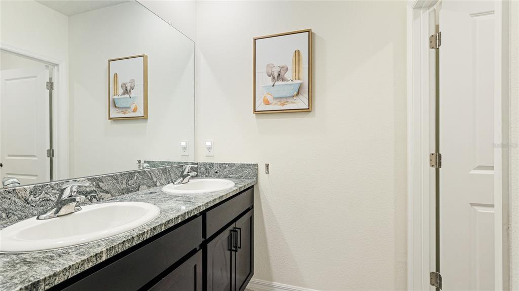 2118 Grand Flora Trail Bradenton, FL 34208 - Photo 45 of 67 a bathroom with a granite countertop sink and a mirror