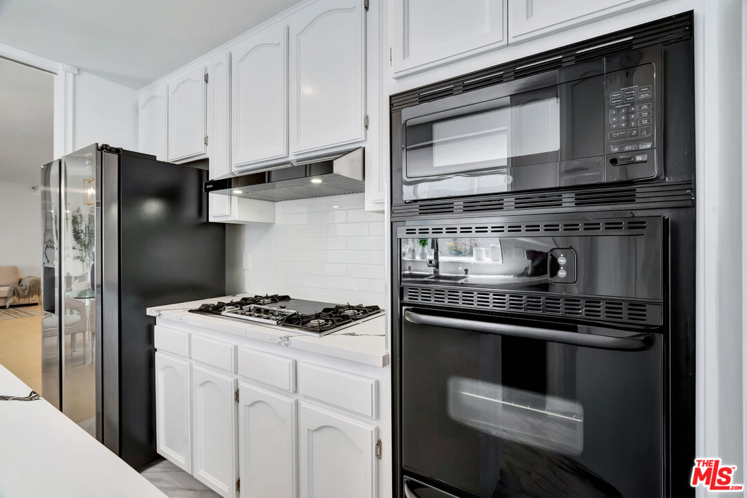 10531 Ashton Avenue, Unit 201 Los Angeles, CA 90024 - Photo 13 of 27 a kitchen with stainless steel appliances granite countertop a stove and a refrigerator