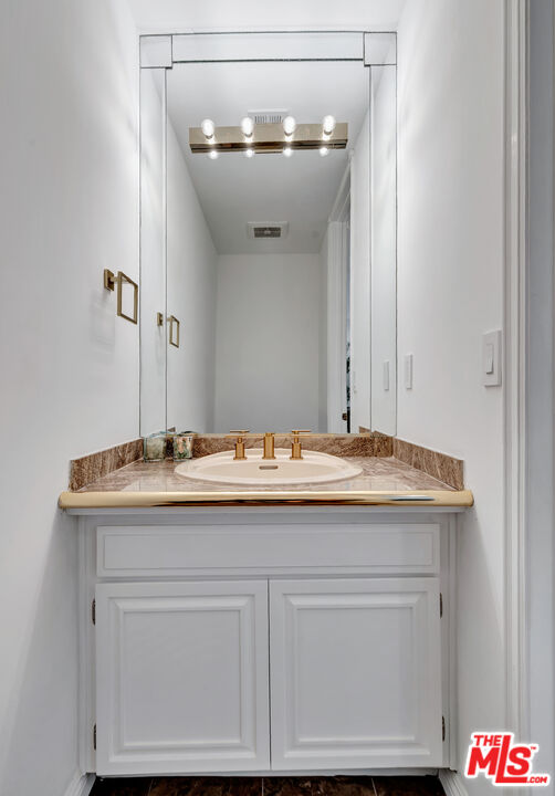 10531 Ashton Avenue, Unit 201 Los Angeles, CA 90024 - Photo 17 of 27 a bathroom with a sink and a mirror