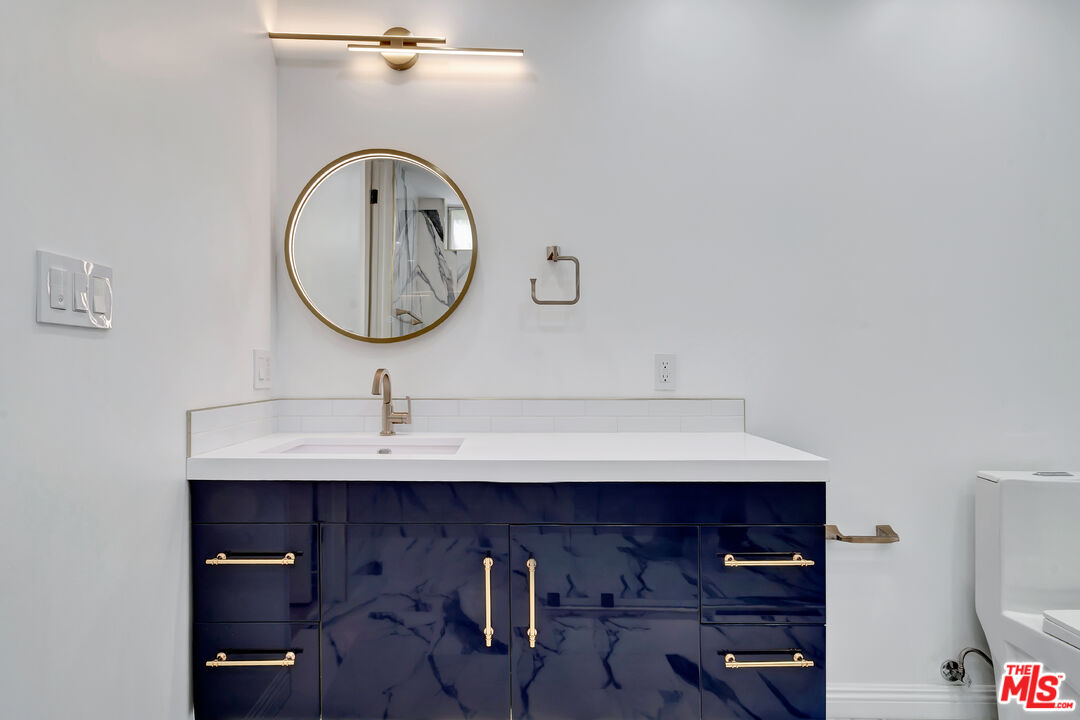 10531 Ashton Avenue, Unit 201 Los Angeles, CA 90024 - Photo 26 of 27 a bathroom with a sink and a mirror