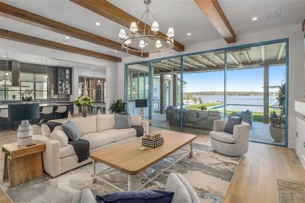 a living room with furniture a dining table and a chandelier