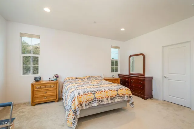 a bedroom with a bed and a dresser next to a window