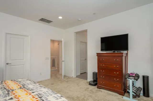 a bedroom with a dresser and a flat screen tv