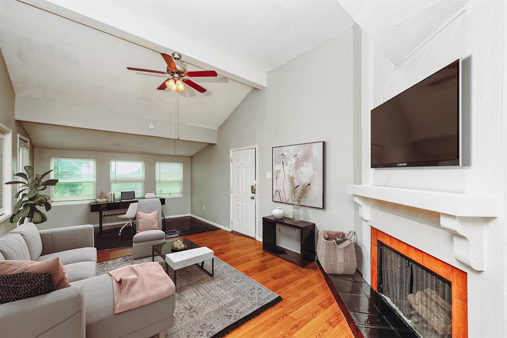9696 Walnut Street, Unit 1216 Dallas, TX 75243 - Photo 1 of 19 Open-concept living space featuring vaulted ceilings with exposed beams, wood-finish flooring, a ceiling fan, and multiple windows
