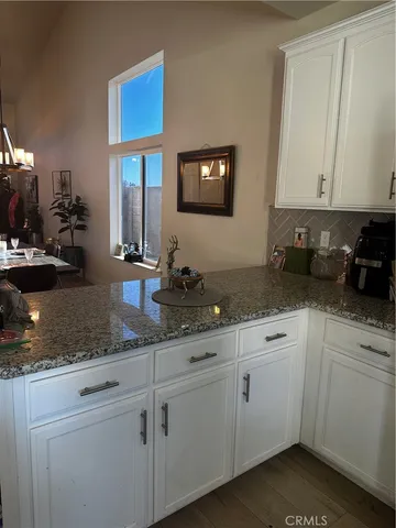a kitchen with granite countertop white cabinets and white appliances