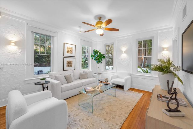 a living room with furniture a chandelier and a large window