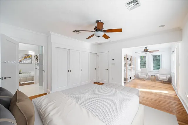 a bedroom with a bed a large window and glass door