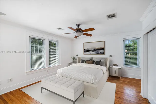 a bedroom with a bed couches and a flat tv screen