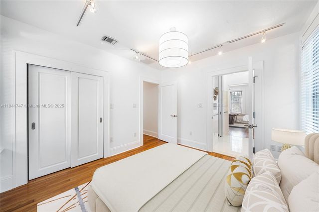 a bedroom with a bed and wooden floor