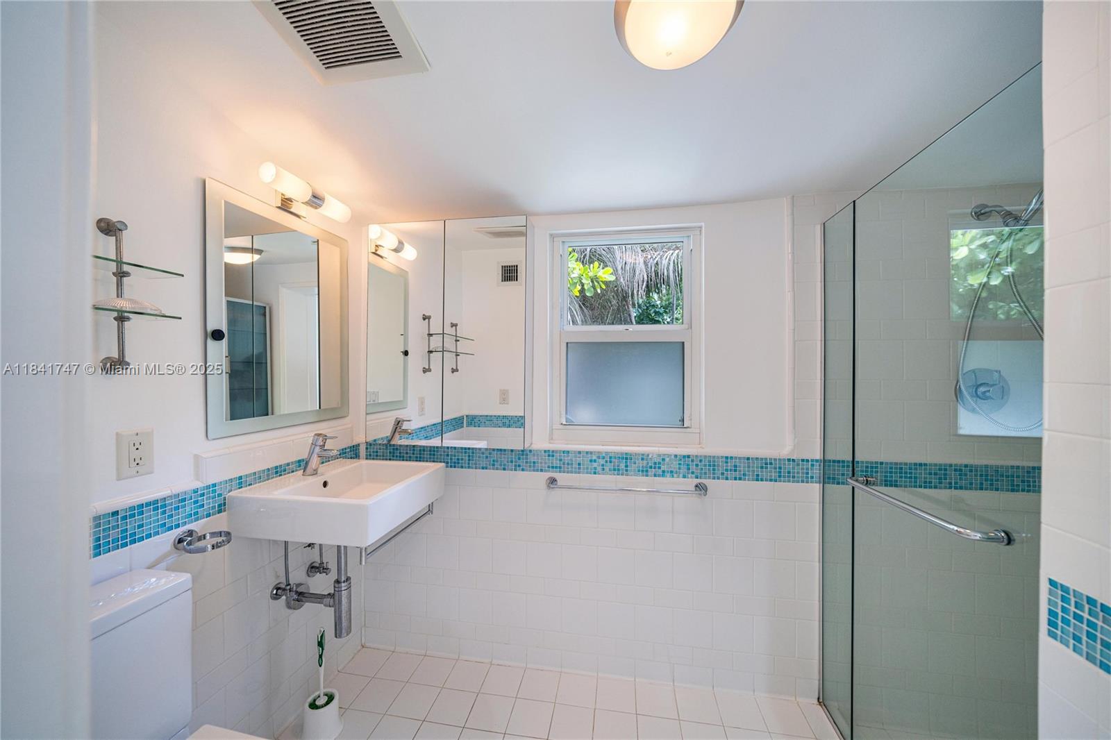 671 Northeast 57th Street Miami, FL 33137 - Photo 38 of 48 a bathroom with a granite countertop sink and a mirror