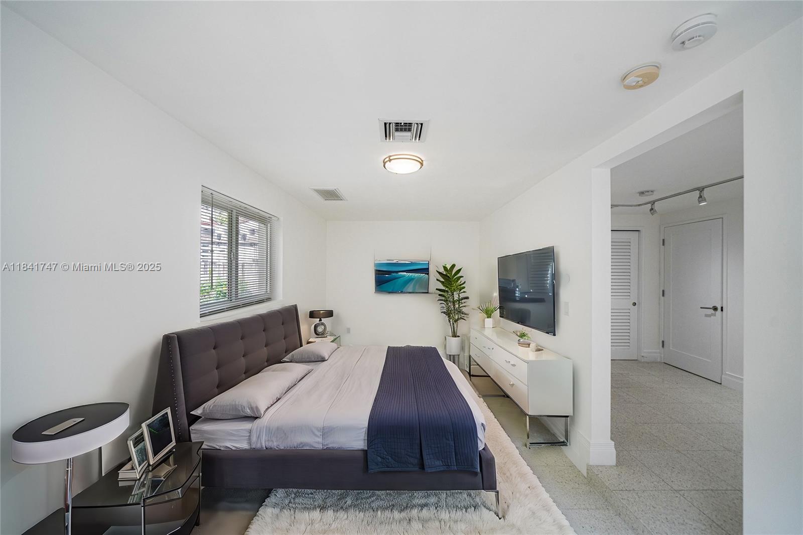 671 Northeast 57th Street Miami, FL 33137 - Photo 40 of 48 a bedroom with a bed and a flat screen tv