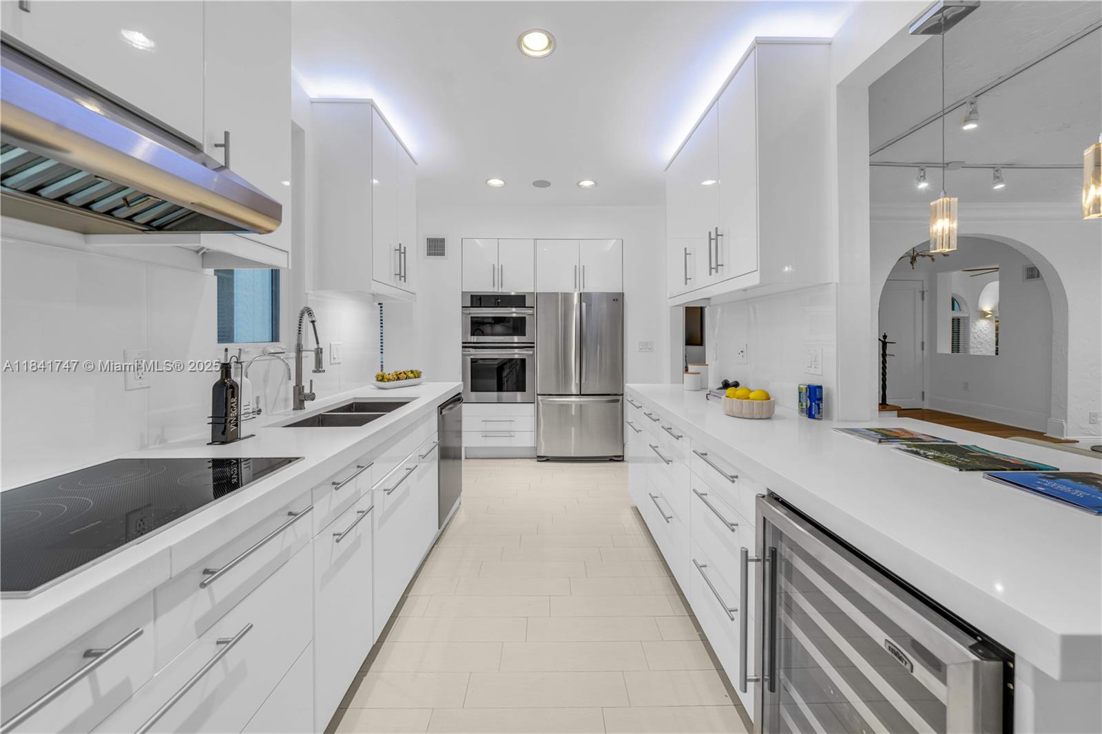 671 Northeast 57th Street Miami, FL 33137 - Photo 8 of 48 a large kitchen with stainless steel appliances kitchen island a large counter top a stove and a sink