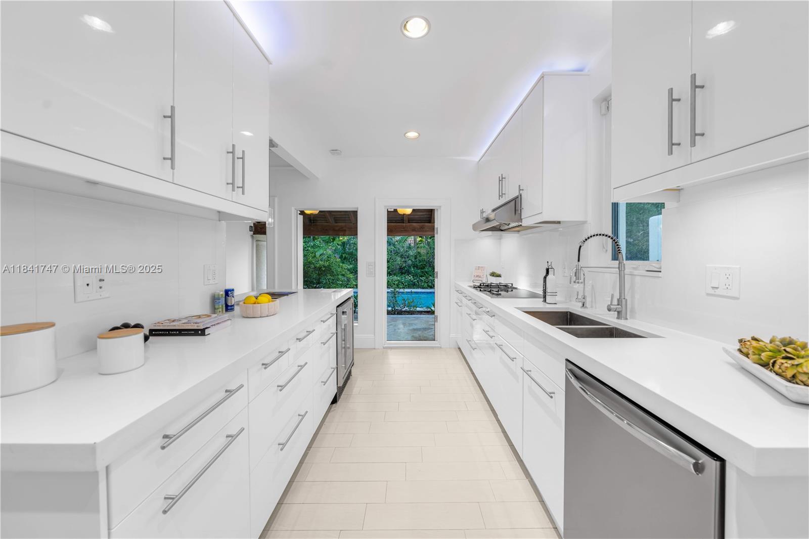 671 Northeast 57th Street Miami, FL 33137 - Photo 10 of 48 a kitchen with counter top space a sink stainless steel appliances and cabinets