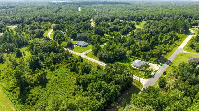 an aerial view of a house with a yard and lake view