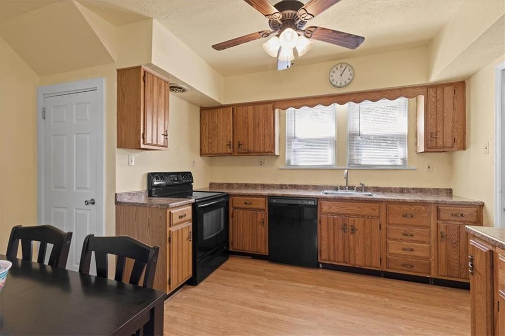 450 Irvin Avenue Rochester, PA 15074 - Photo 13 of 30 a kitchen with stainless steel appliances granite countertop a stove top oven a sink dishwasher a dining table and chairs with wooden floor
