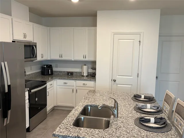 a kitchen with sink refrigerator and stove
