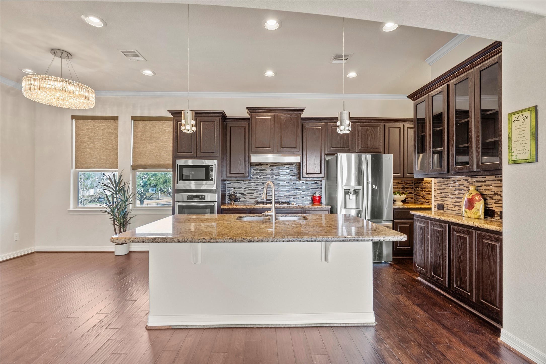 10218 Spring Shadows Park Circle Houston, TX 77080 - Photo 15 of 46 a view of a kitchen with kitchen island stainless steel appliances a stove a refrigerator a sink and wooden floor