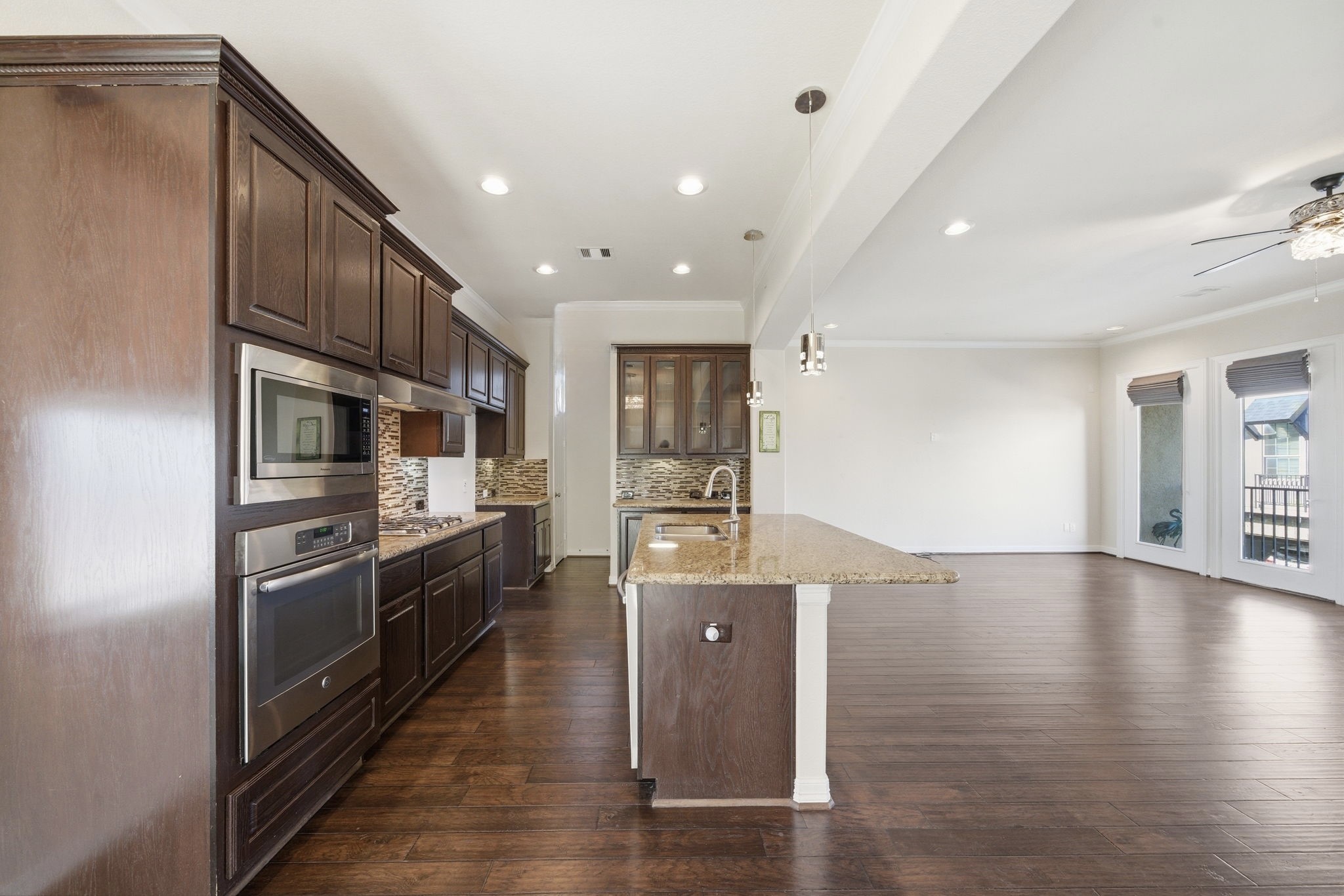 10218 Spring Shadows Park Circle Houston, TX 77080 - Photo 19 of 46 a kitchen with stainless steel appliances granite countertop a refrigerator a stove and a wooden floors