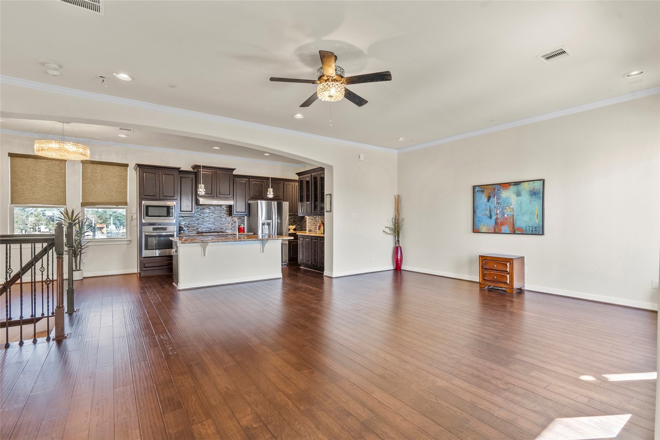 10218 Spring Shadows Park Circle Houston, TX 77080 - Photo 22 of 46 a view of a living room a kitchen with wooden floor and a ceiling fan