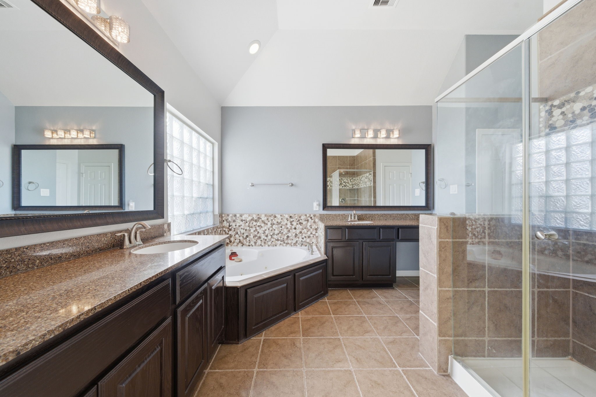 10218 Spring Shadows Park Circle Houston, TX 77080 - Photo 29 of 46 a bathroom with a double vanity sink a toilet a mirror and shower