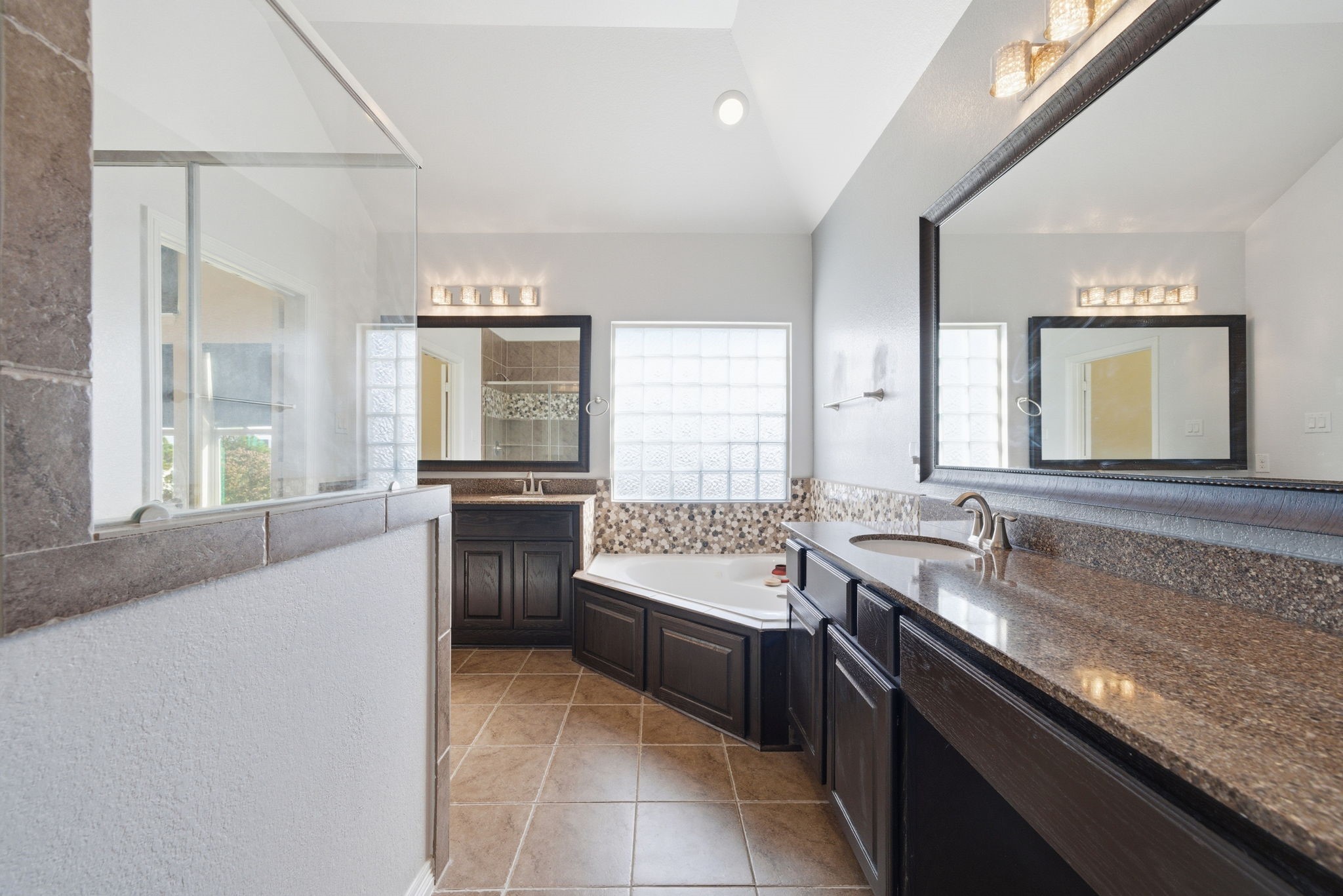 10218 Spring Shadows Park Circle Houston, TX 77080 - Photo 31 of 46 a large bathroom with a granite countertop sink a large mirror and a bathtub