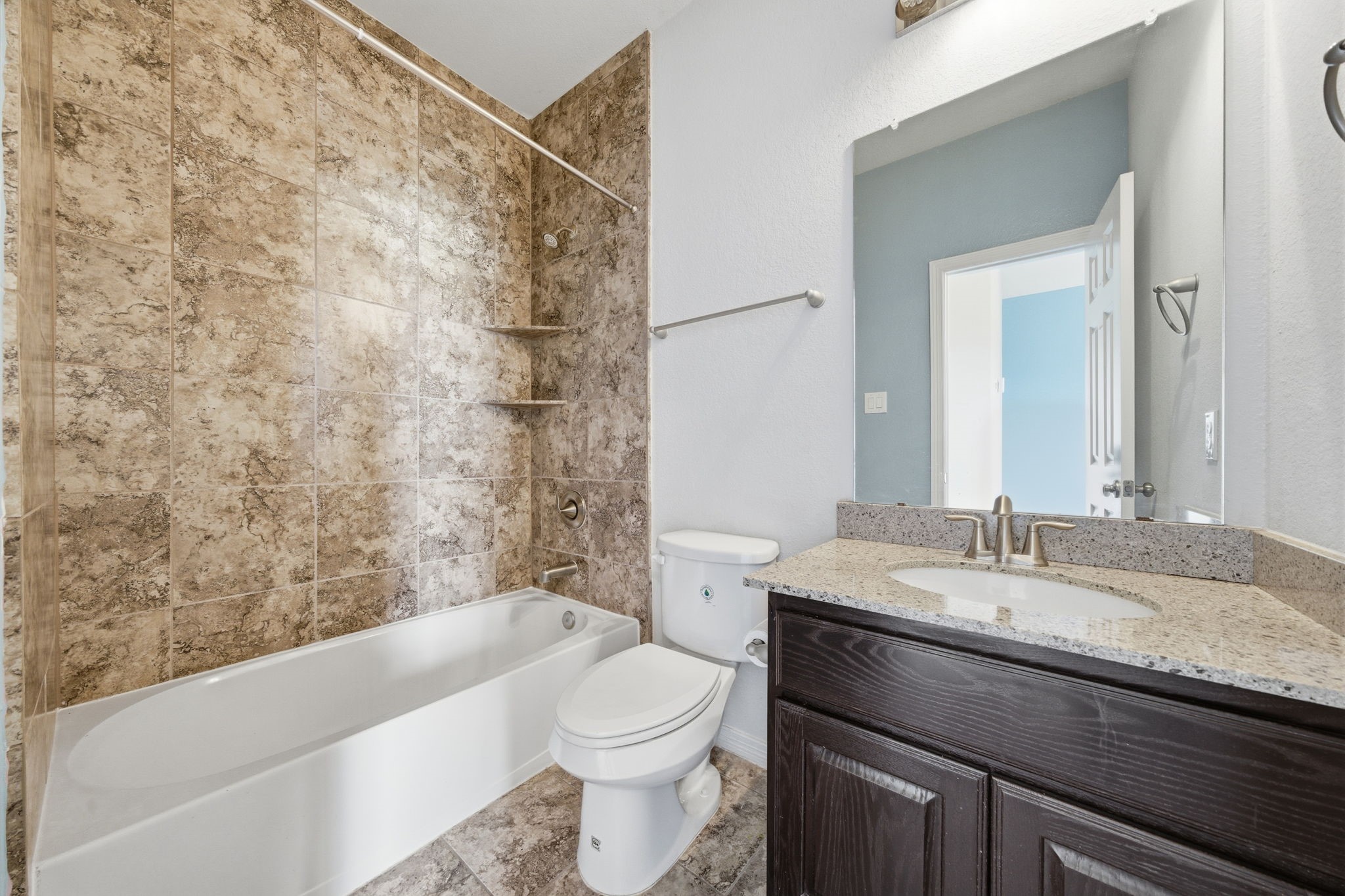 10218 Spring Shadows Park Circle Houston, TX 77080 - Photo 37 of 46 a bathroom with a granite countertop bathtub sink vanity mirror and toilet