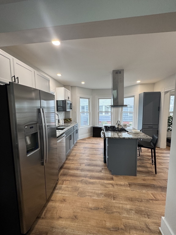 48 Santa Barbara Street Springfield, MA 01104 - Photo 11 of 33 a kitchen with stainless steel appliances kitchen island a stove a refrigerator a kitchen island a stove and a refrigerator