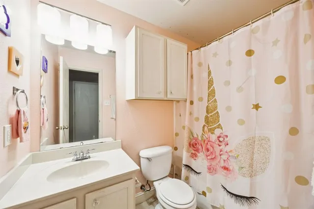 a bathroom with a sink a toilet and shower curtain