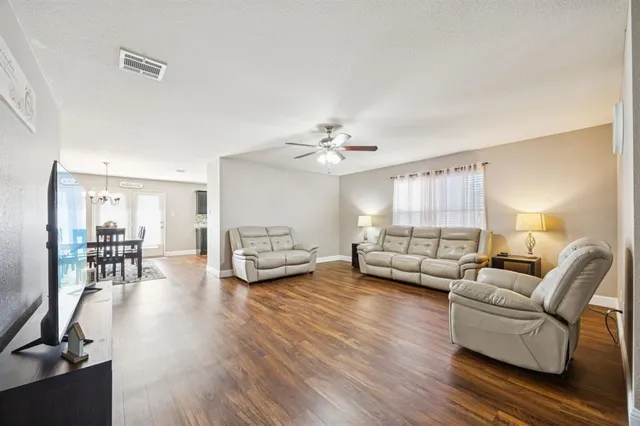 a living room with furniture and wooden floor