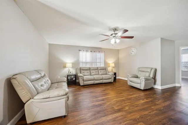 a living room with furniture and a large window with wooden floor