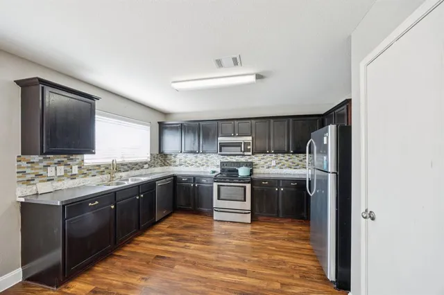 a large kitchen with a stove top oven and sink
