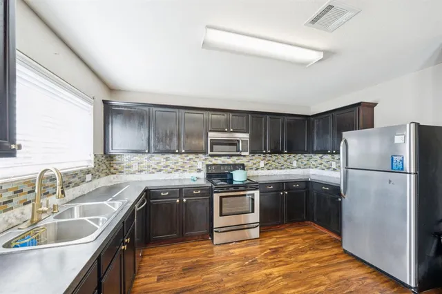 a kitchen with stainless steel appliances granite countertop a sink stove and refrigerator