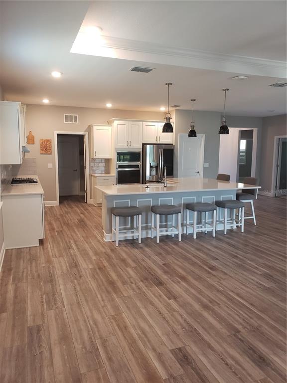 9013 Southwest 79th Lane Ocala, FL 34481 - Photo 5 of 21 a living room with kitchen view and a wooden floor