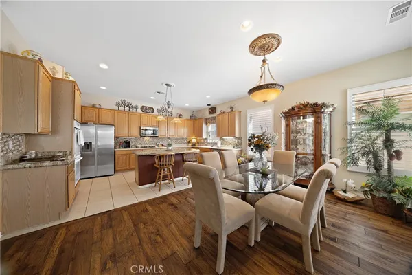 a dining room with stainless steel appliances granite countertop a stove and chairs