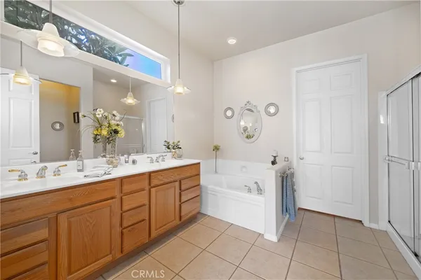 a spacious bathroom with a double vanity sink a mirror and a bathtub
