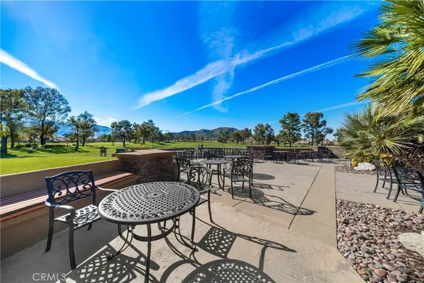 a view of a chairs and table in patio with a lake view