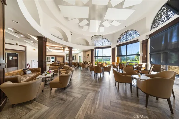 a living room with furniture a large window and wooden floor